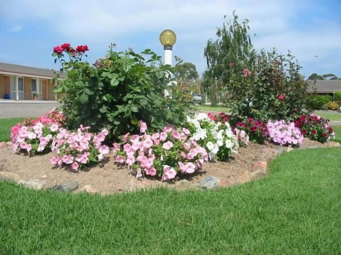 Lawn and garden bed with the motel wing behind