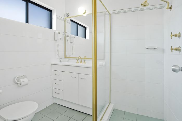En suite bathroom with a walk-in shower, vanity and mirror