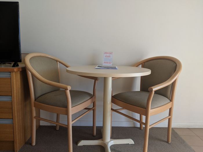 In-room dining setting with a round table, two chairs and a television
